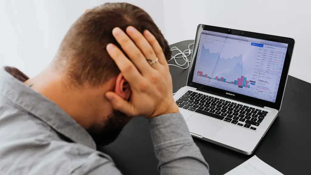 A stressed man looking at a laptop screen showing declining graphs and performance metrics, representing the impact of penalties on website rankings.